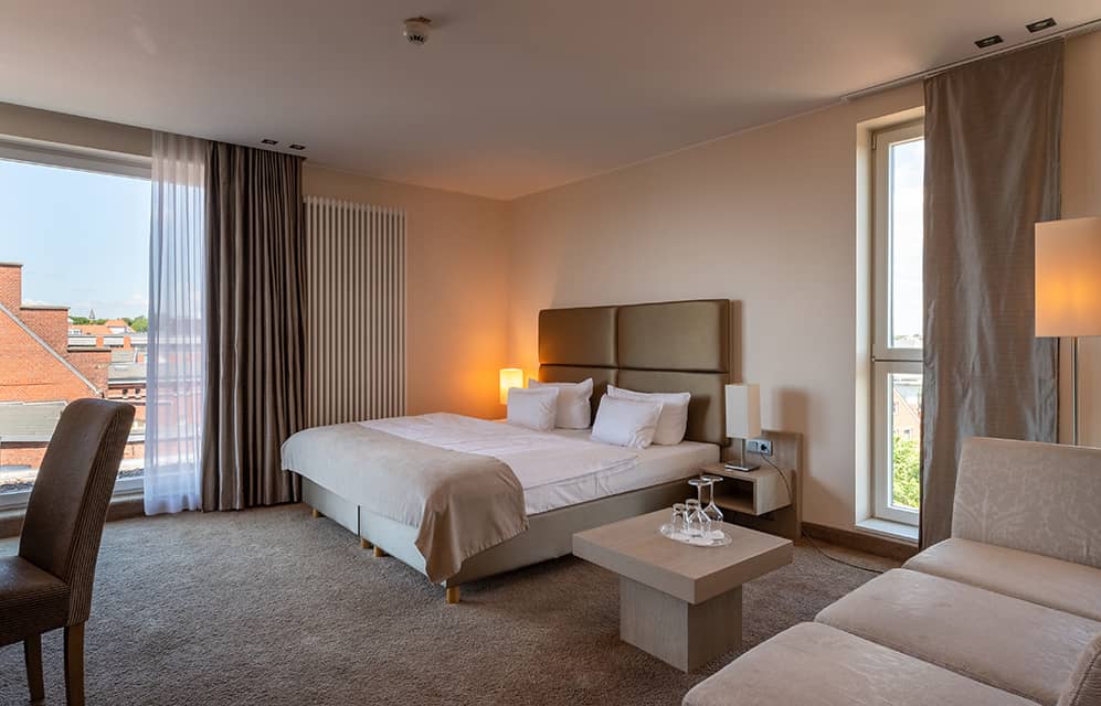 Zimmeransicht mit Bett und stylischem Interieur im For Two + View Zimmer.