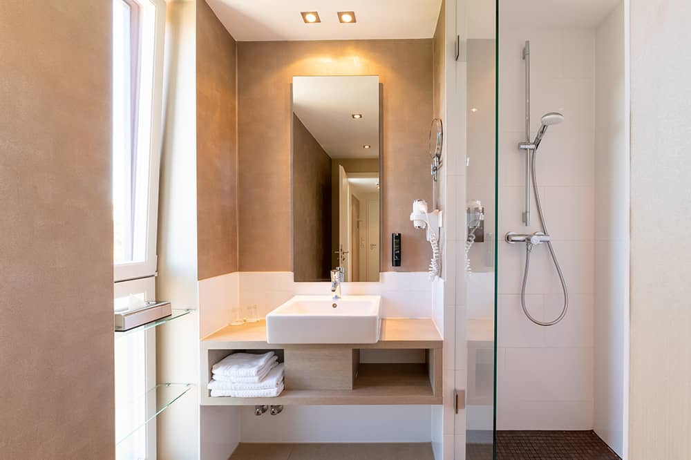 Ansicht des Badezimmers mit Dusche im And More Zimmer.