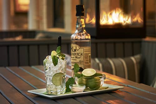 Cocktail auf einem Tablet vor einem Loungefeuer.